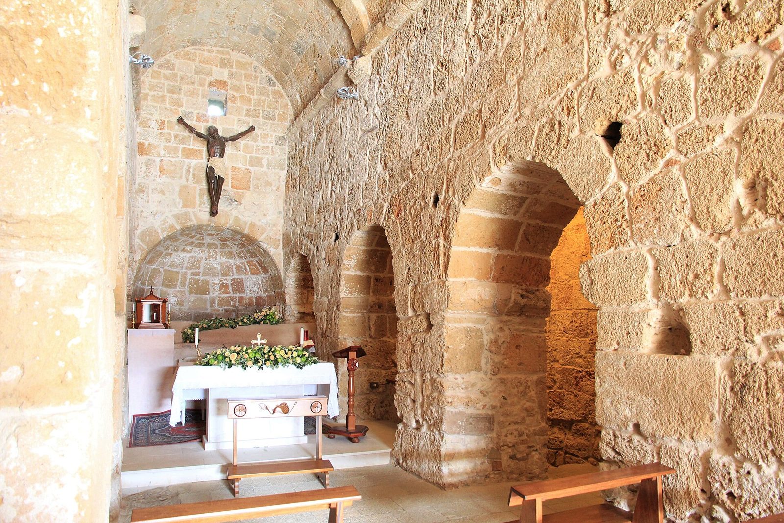 Interno in pietra della chiesa di Sant'Efisio a Nora con altare e archi